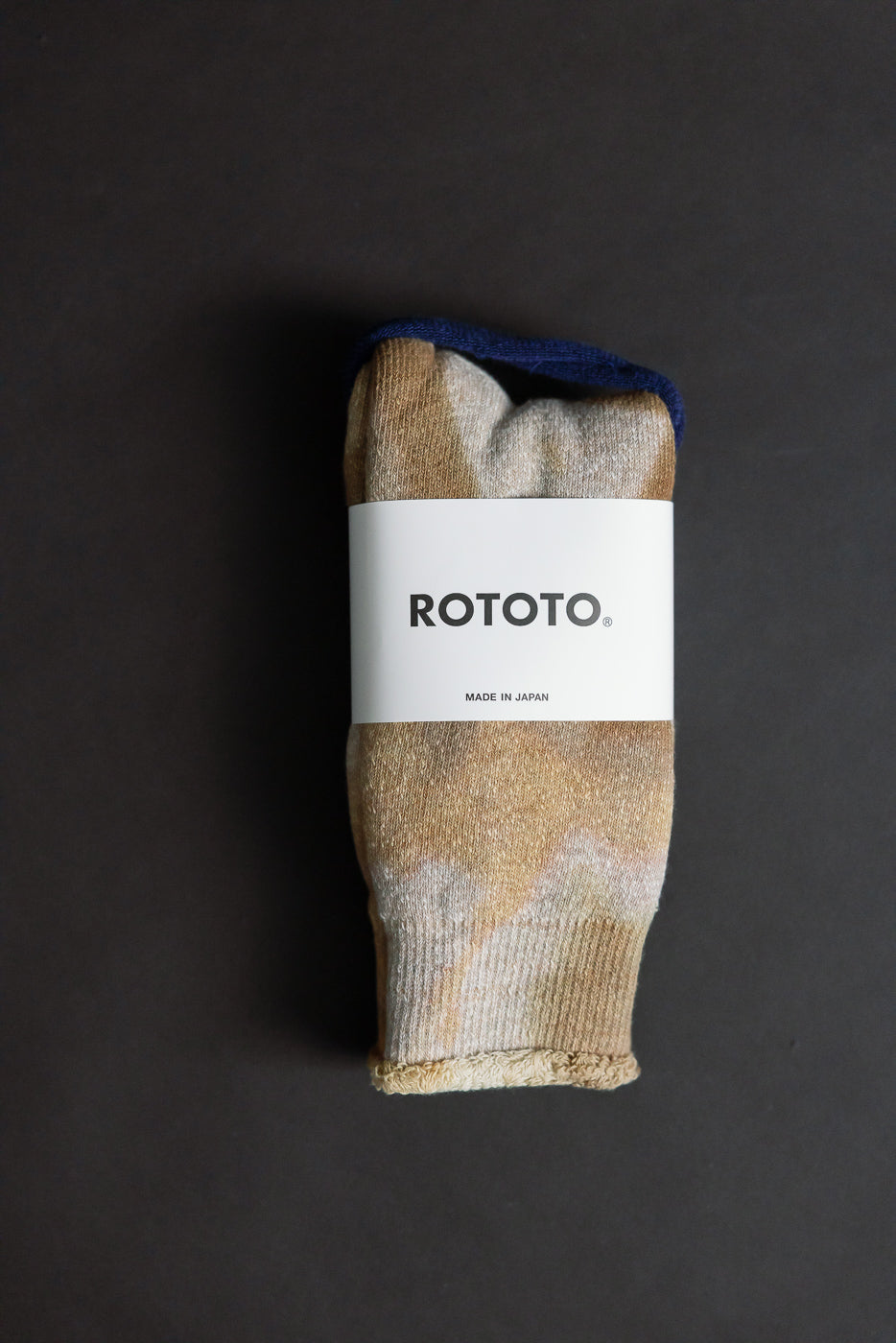 Close-up of tie-dye beige and brown crew socks, flat lay showing front with visible texture and label.