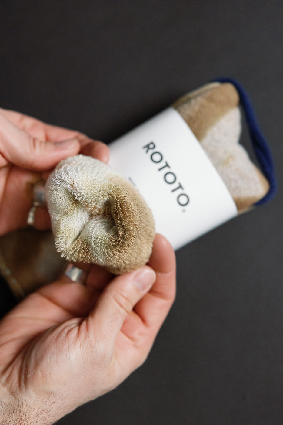 Close-up of tie-dye beige brown crew socks, showing looped pile fabric texture at toe end.
