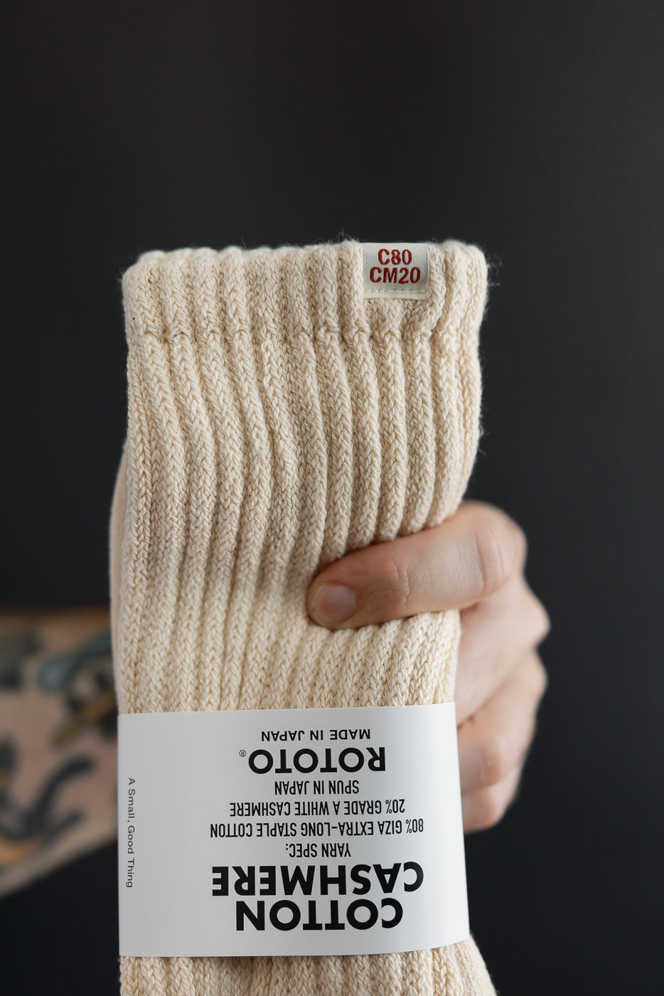 Close-up of the top hem and tag of cream-colored cotton cashmere socks.