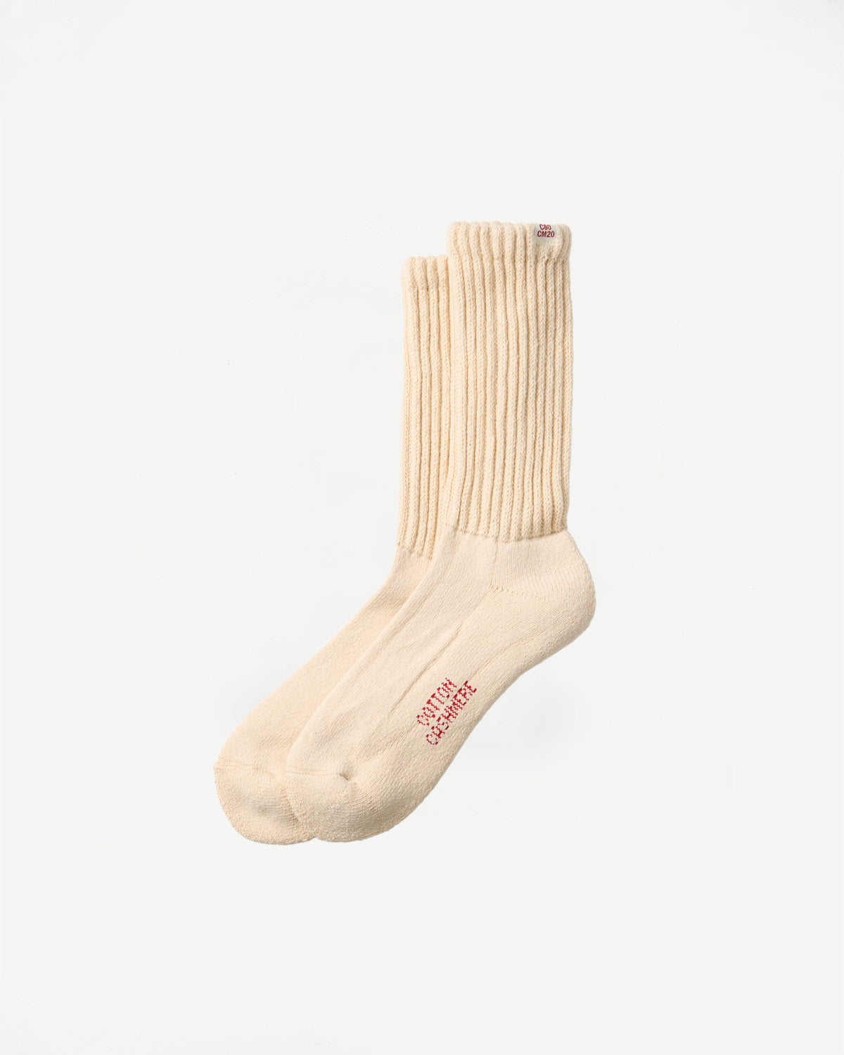 Flat lay side view of cream ribbed cashmere socks showing red text detail.