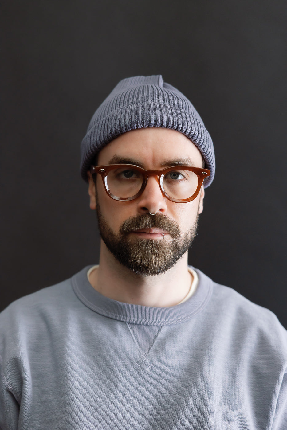 Front close-up of cotton roll-up beanie in faded blue on male model, 5'9, 165lbs, athletic build.