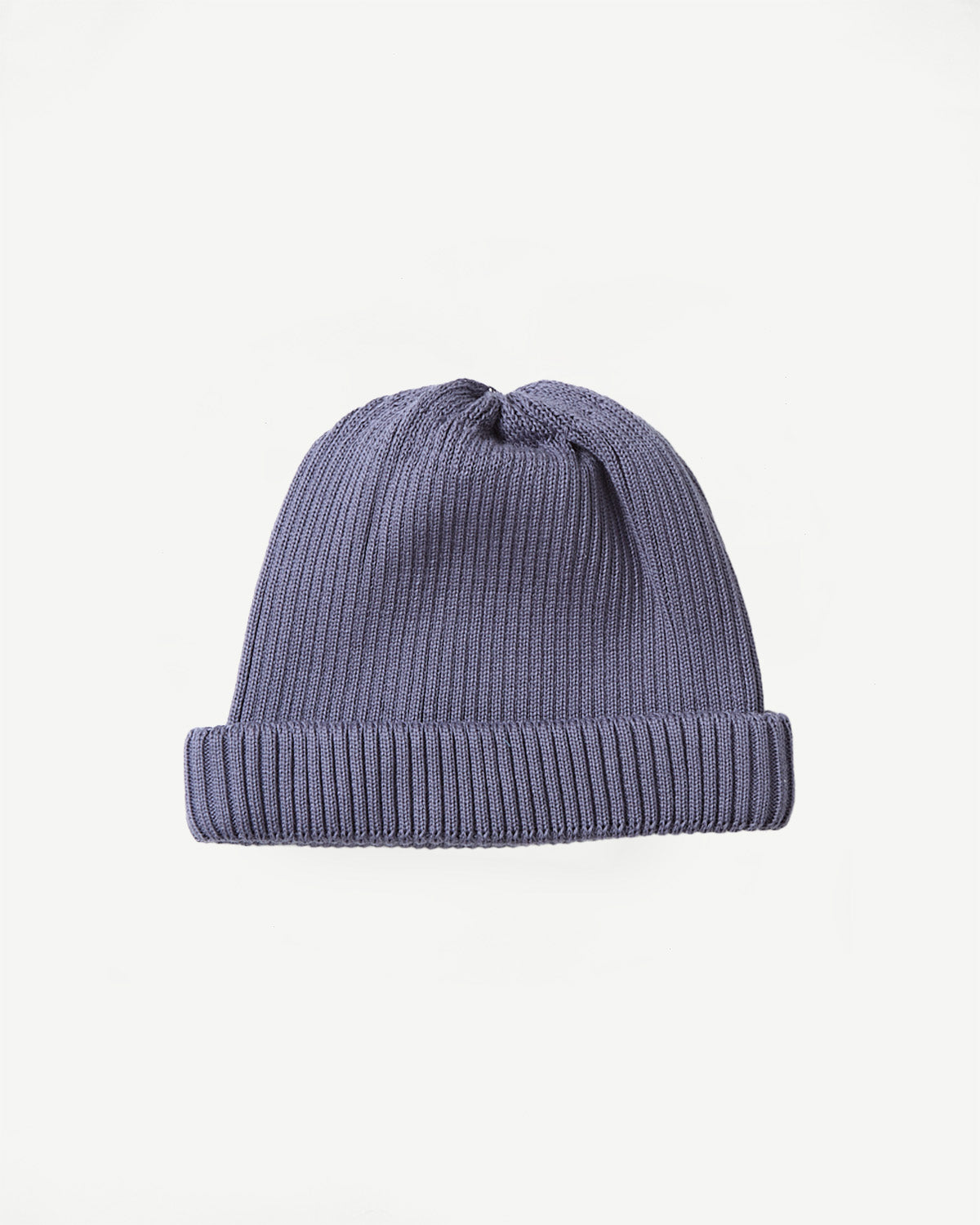 Flat lay front view of ribbed cotton roll-up beanie in faded blue, showing knit texture.