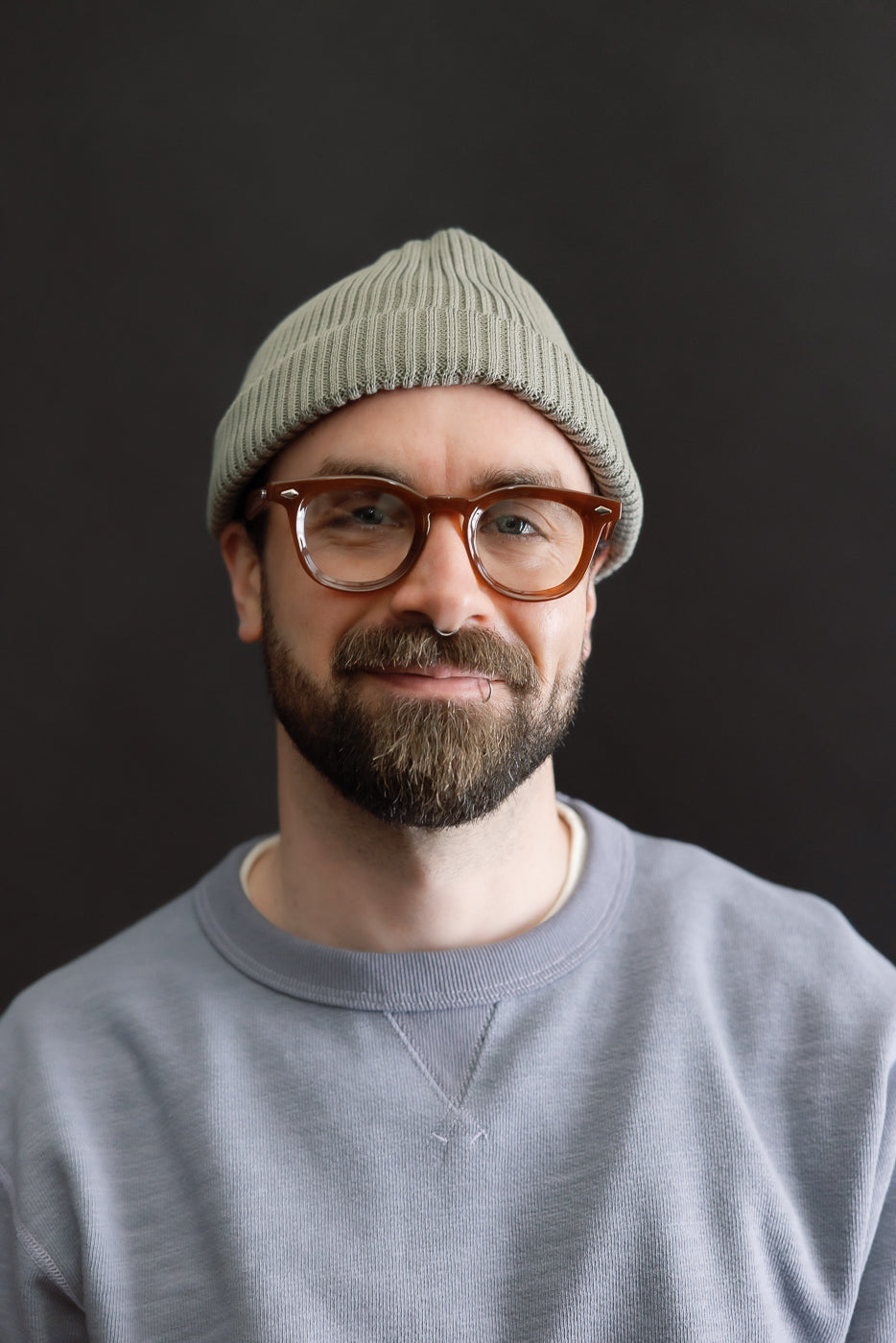 Front close-up of sage cotton roll-up beanie on male model, 5'9