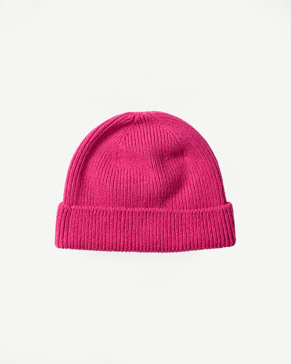 Flat lay, front view of dark pink ribbed knit beanie, folded cuff, fabric texture visible.