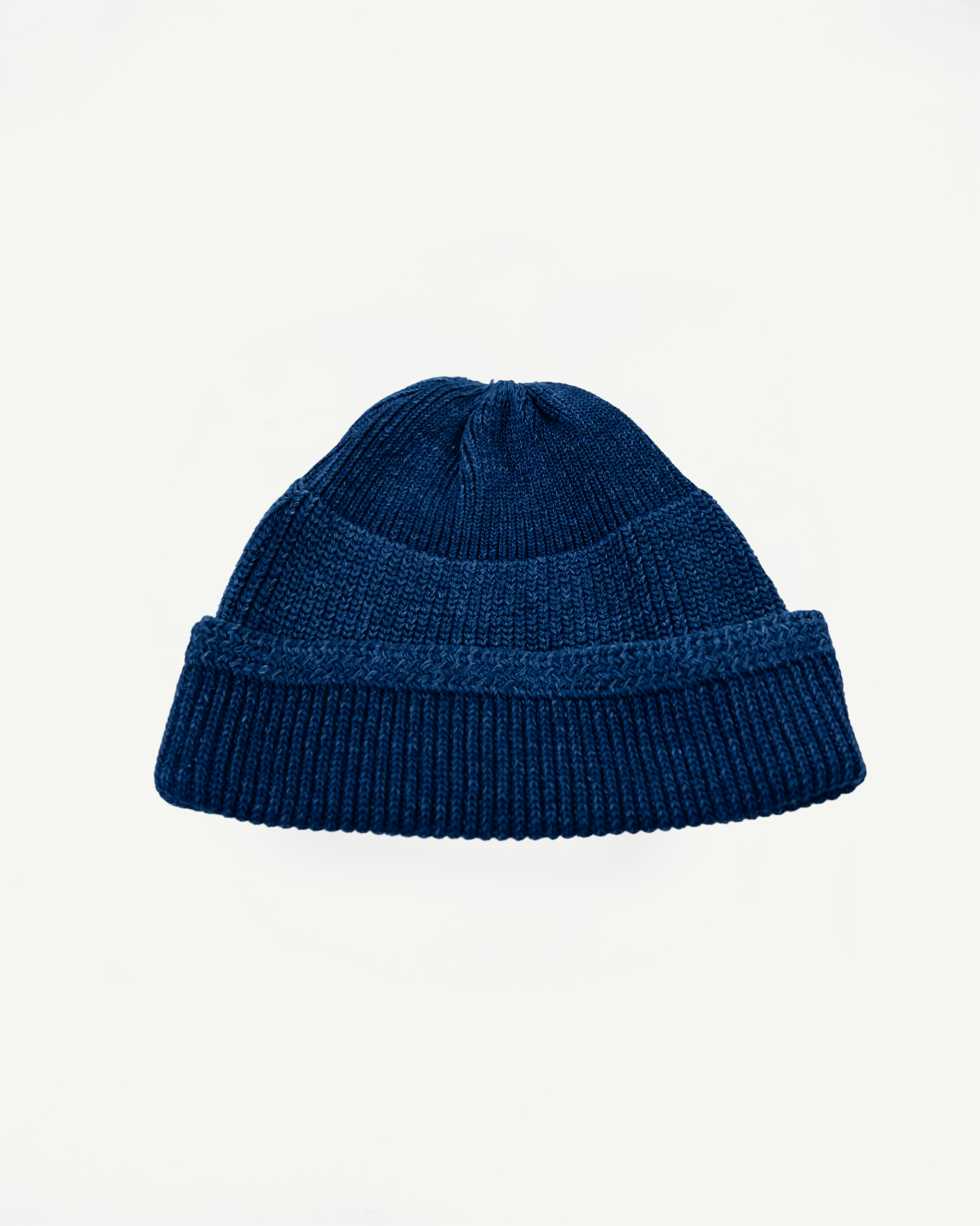 Front view flat lay of a navy blue ribbed knit beanie with a folded cuff.
