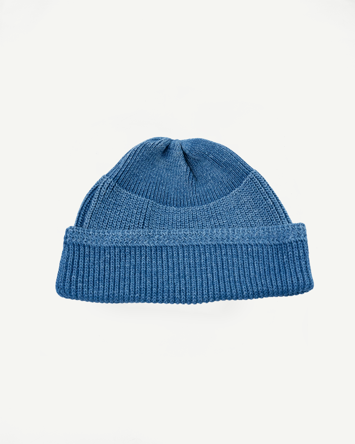 Front view close-up of a blue ribbed knit beanie hat.