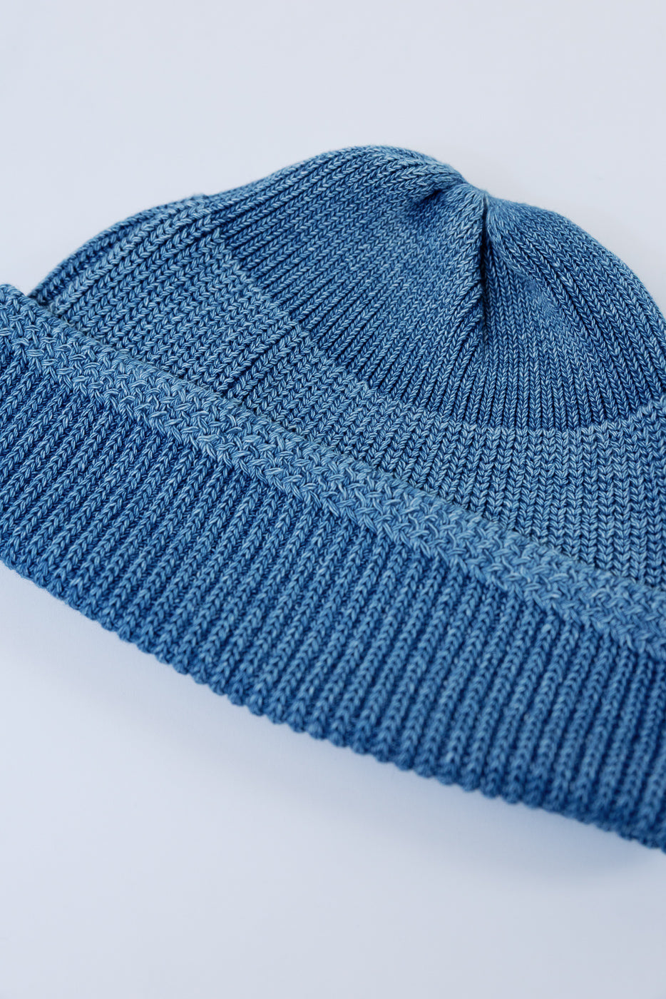 Close-up front view of a blue ribbed knit beanie showing detailed fabric texture.