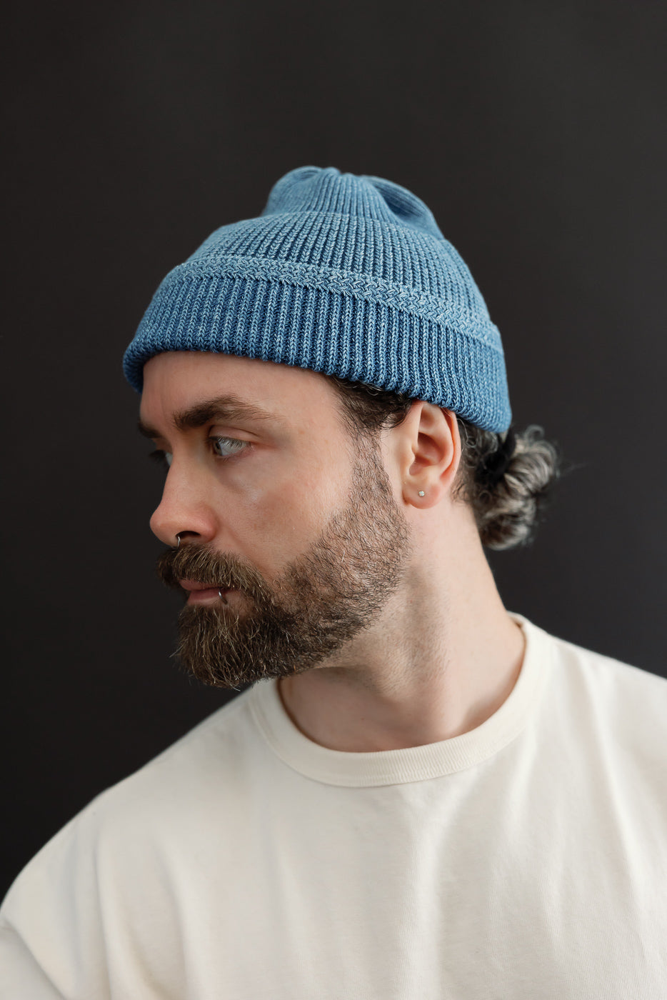 Close-up profile of a blue ribbed beanie on a male model (5'9