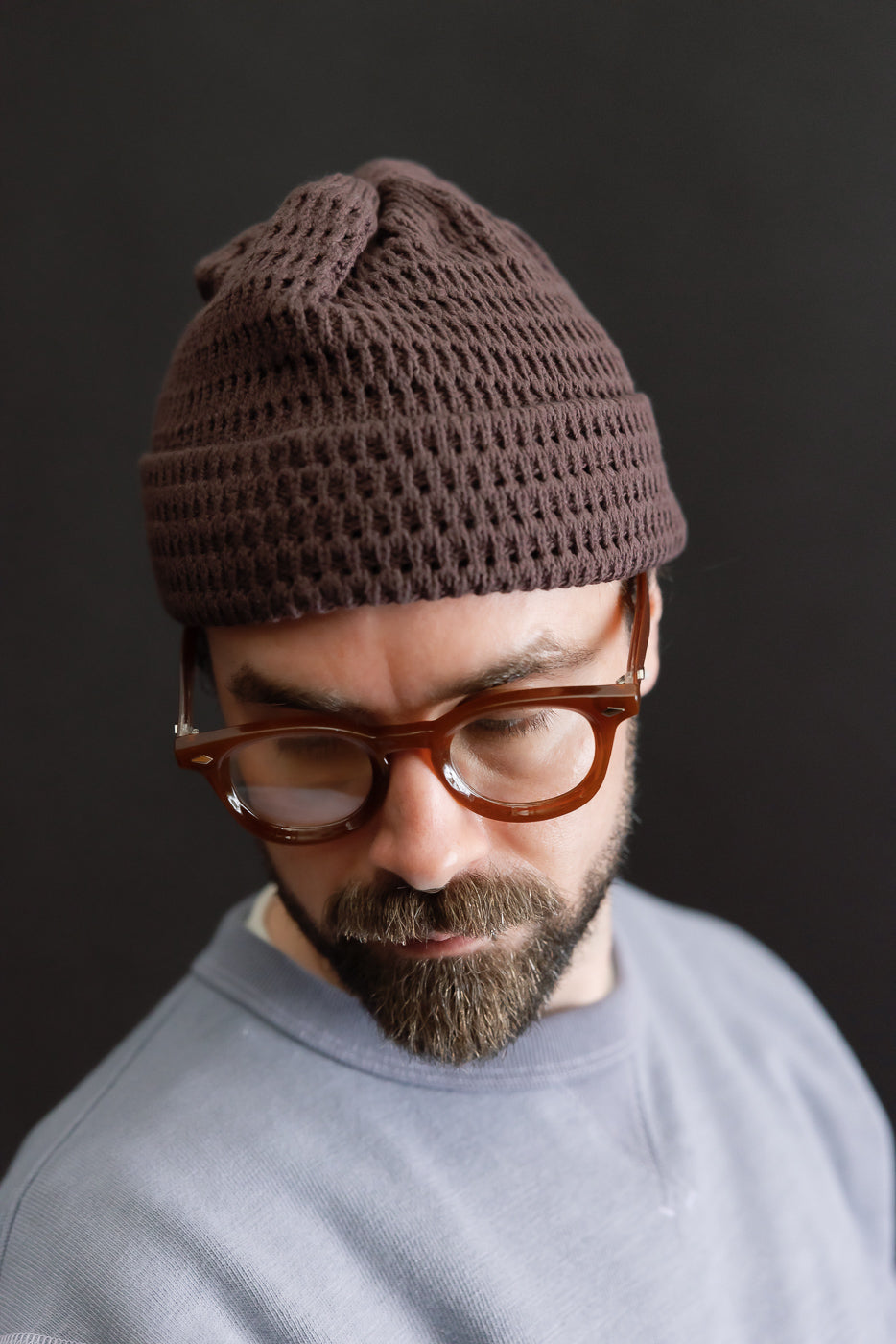 Close-up front view of recycled cotton open knit beanie in light brown on male model, 5'9