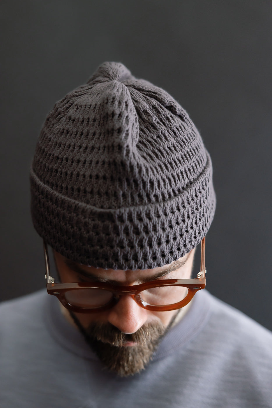 Close-up front view of light charcoal recycled cotton open knit beanie on male model, 5'9