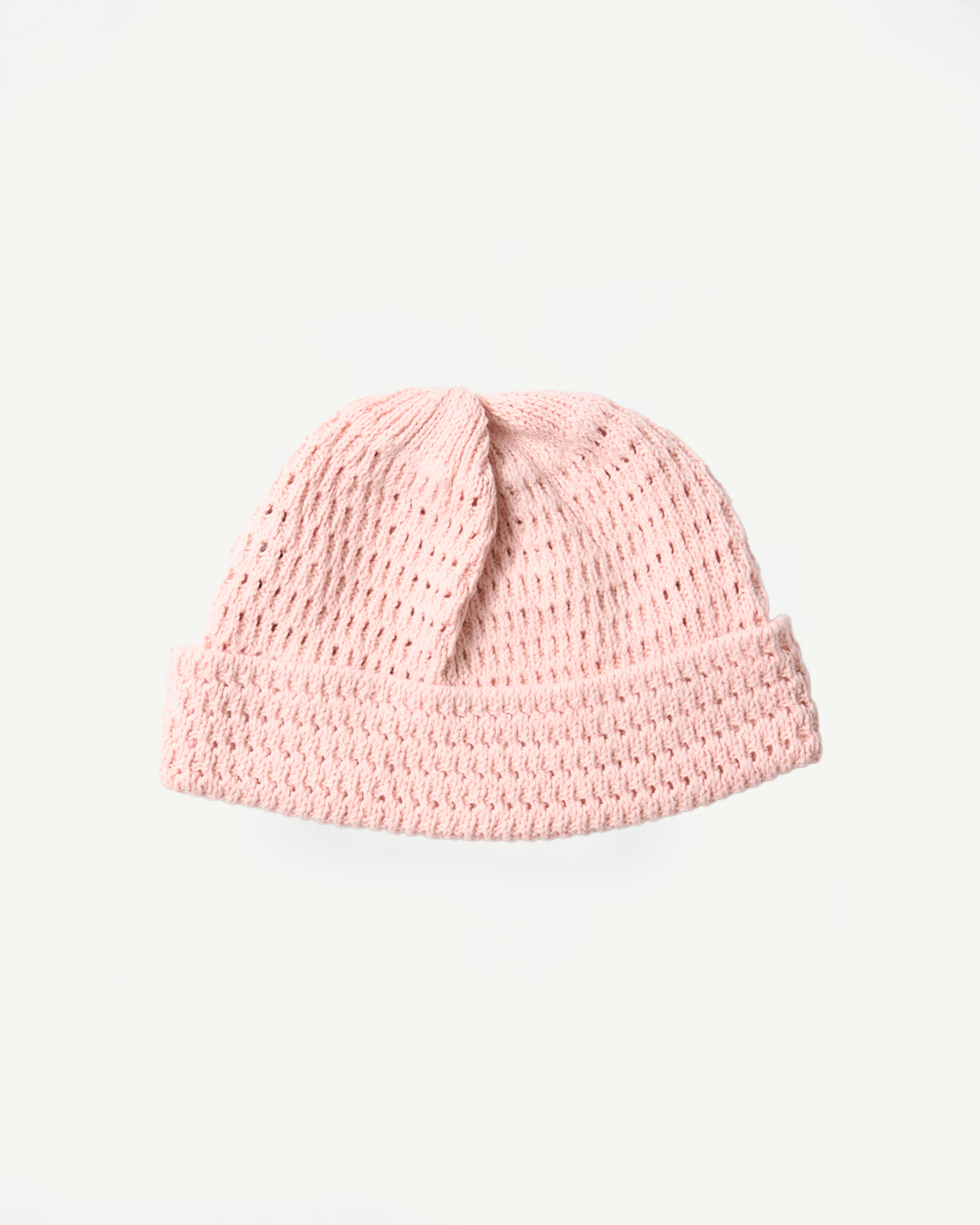 Flat lay front view of light pink open knit beanie, showing texture and folded cuff.