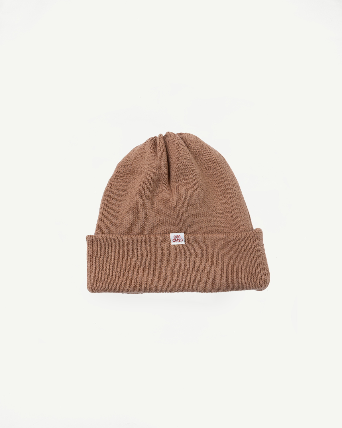 Front view flat lay of a brown knit beanie with a ribbed cuff and small white rectangular tag.