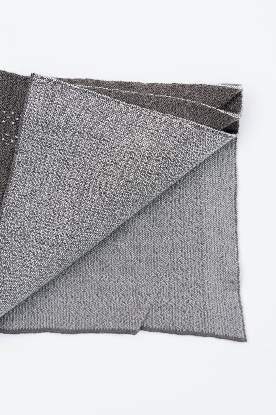 Close-up flat lay showing the front texture and weave of a grey knit fabric.