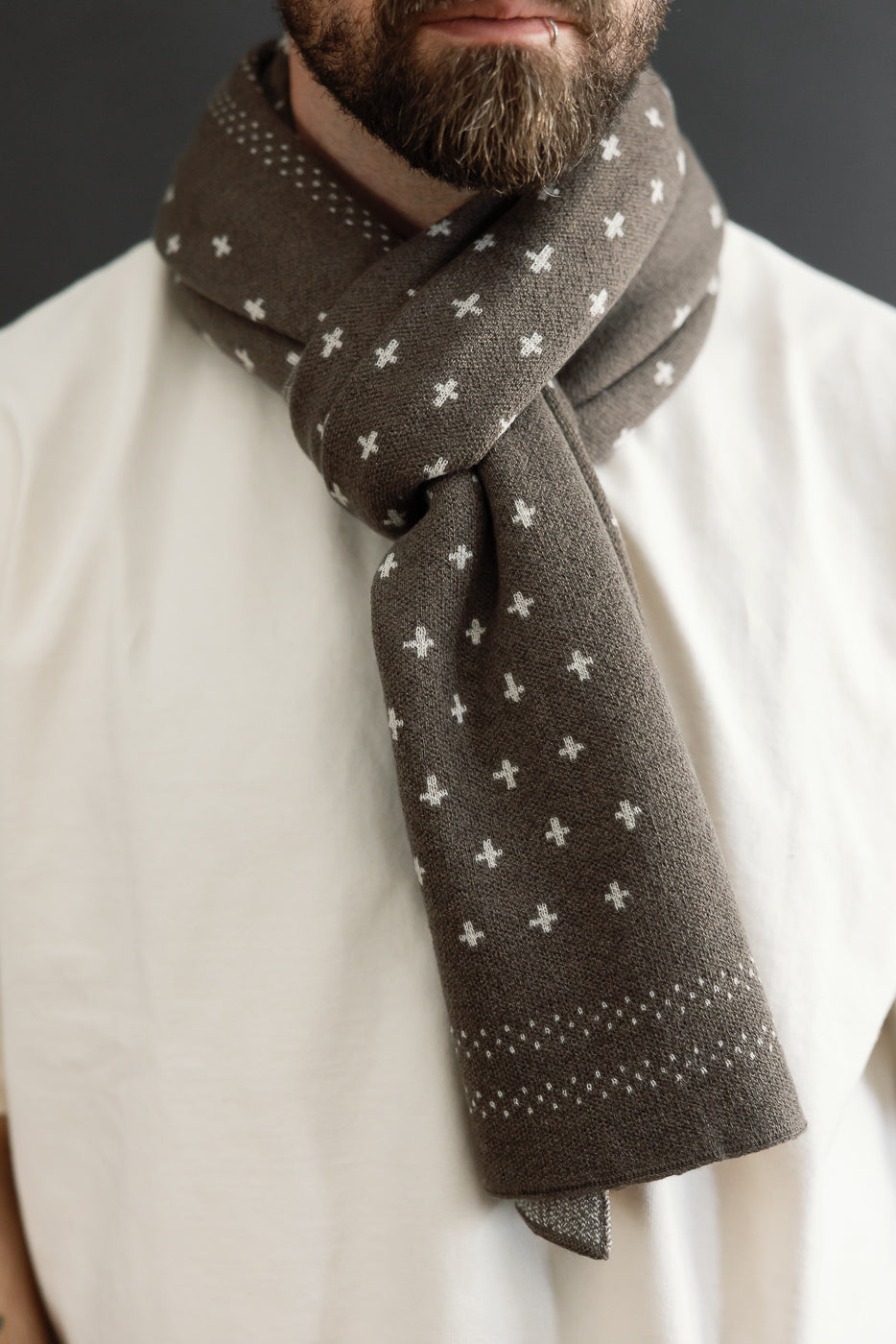 Close-up front view of a brown patterned scarf on a male model, 5'9