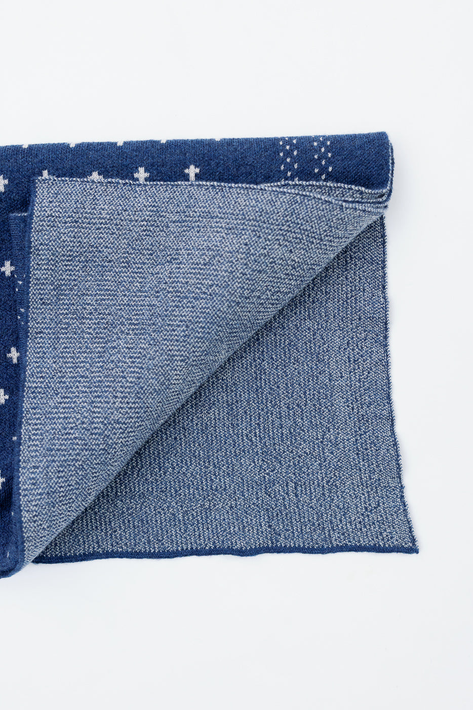 Close-up of the underside texture and blue pattern of a folded fabric item.