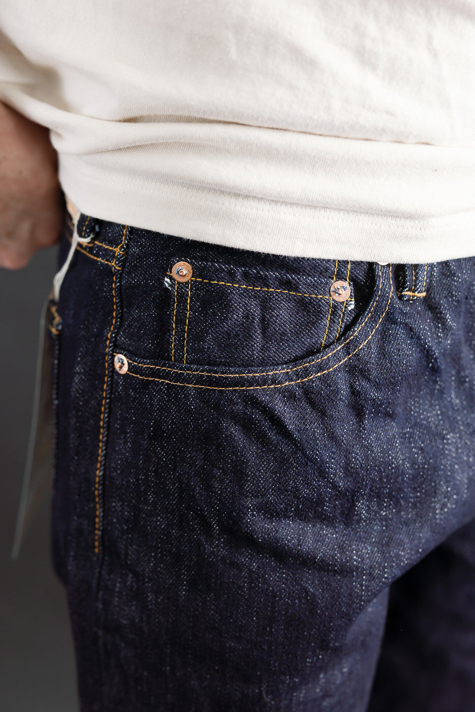 Close-up of front right side of Samurai 15oz washi selvedge denim on male model, showing coin pocket, contrast stitching and rivet details.