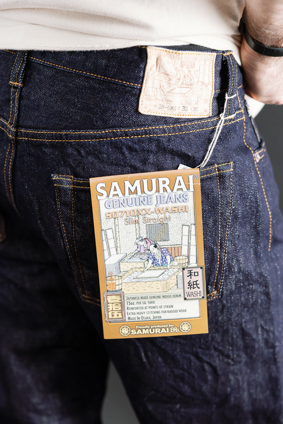 Close-up of male model’s back wearing Samurai S0710xx 15oz limited washi selvedge denim jeans, rear patch and tag details visible. Model is 5'9
