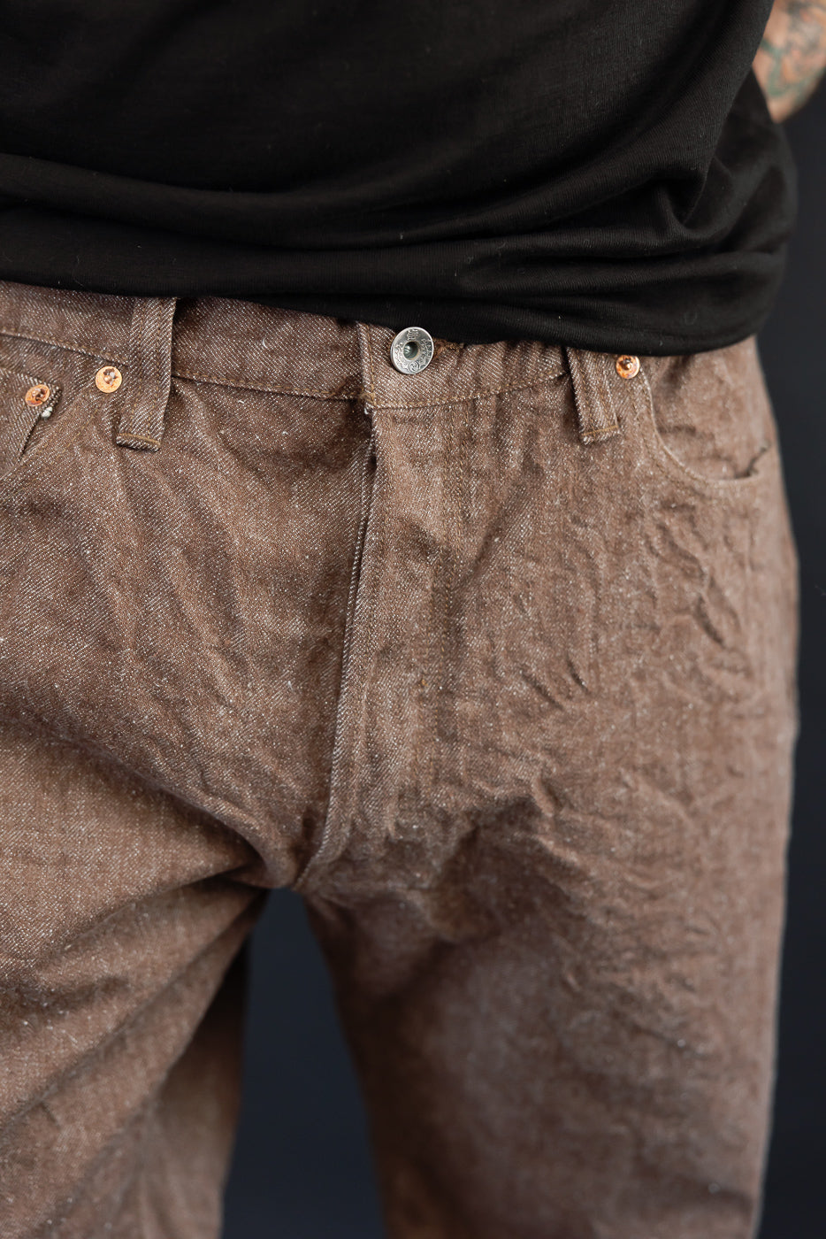 Close-up front view of brown selvedge jeans, male model, 5'9