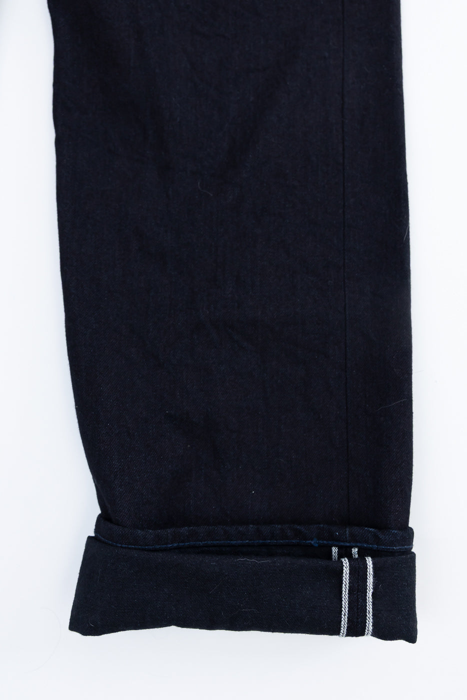 Close-up of cuffed leg hem, front view, showcasing black blue selvedge denim with visible selvedge ID, Samurai S0510XX jeans at Dant Indianapolis.