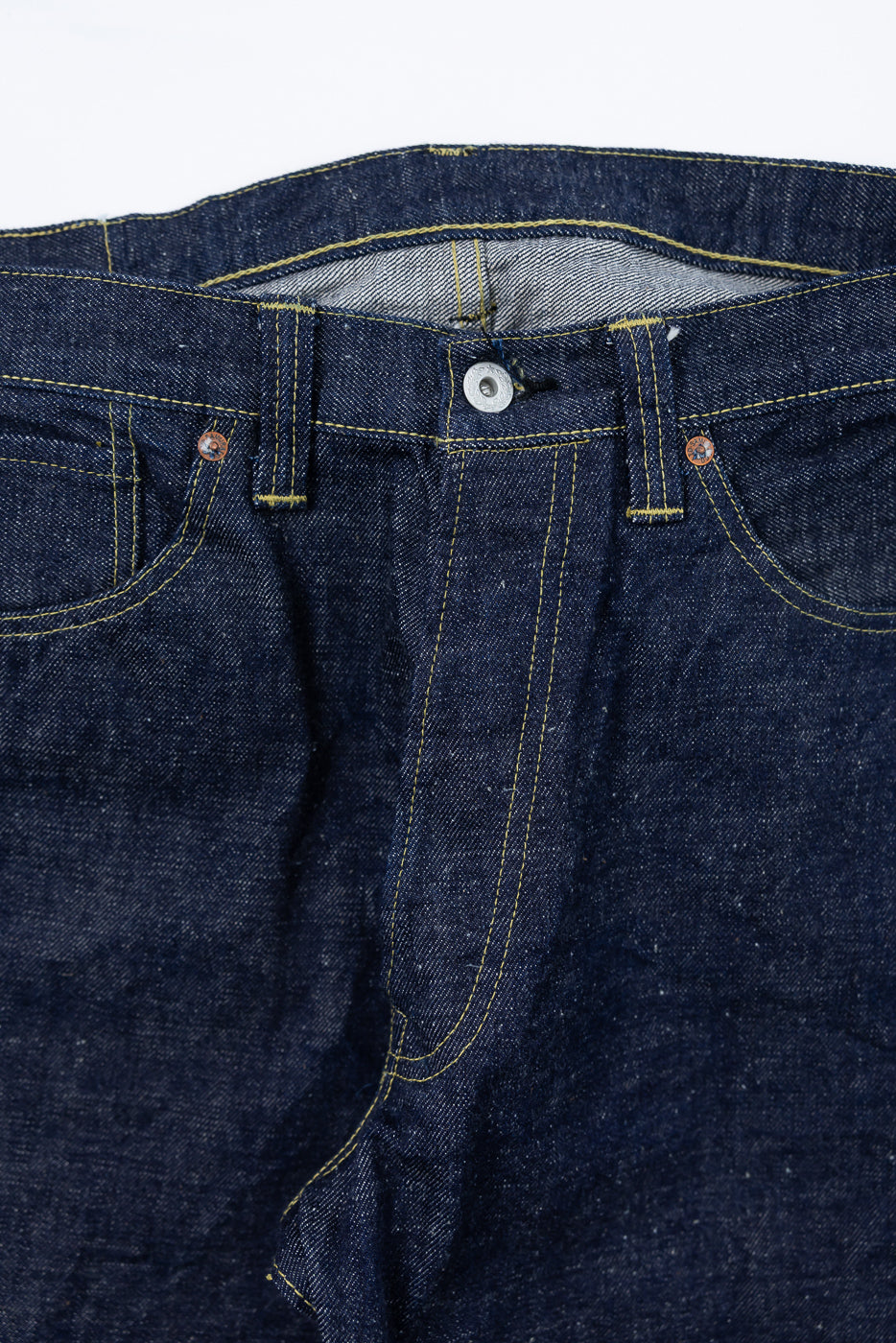 Close-up front view of Samurai S2000HXII selvedge denim jeans, highlighting button, pockets, and yellow stitching detail.