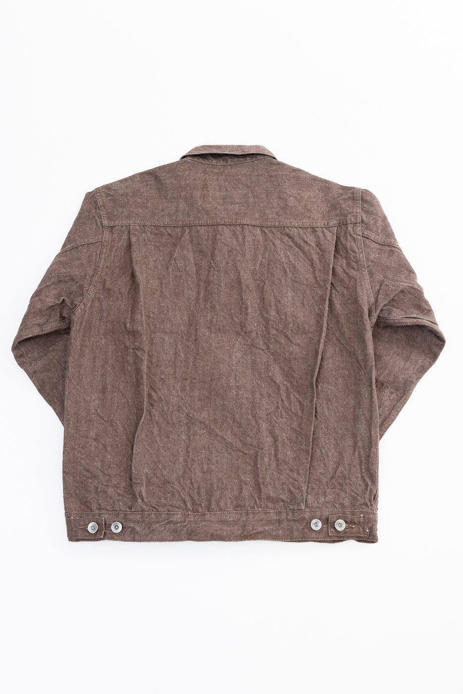 Back view flat lay of brown textured work jacket with buttoned hem, selvedge-style detailing