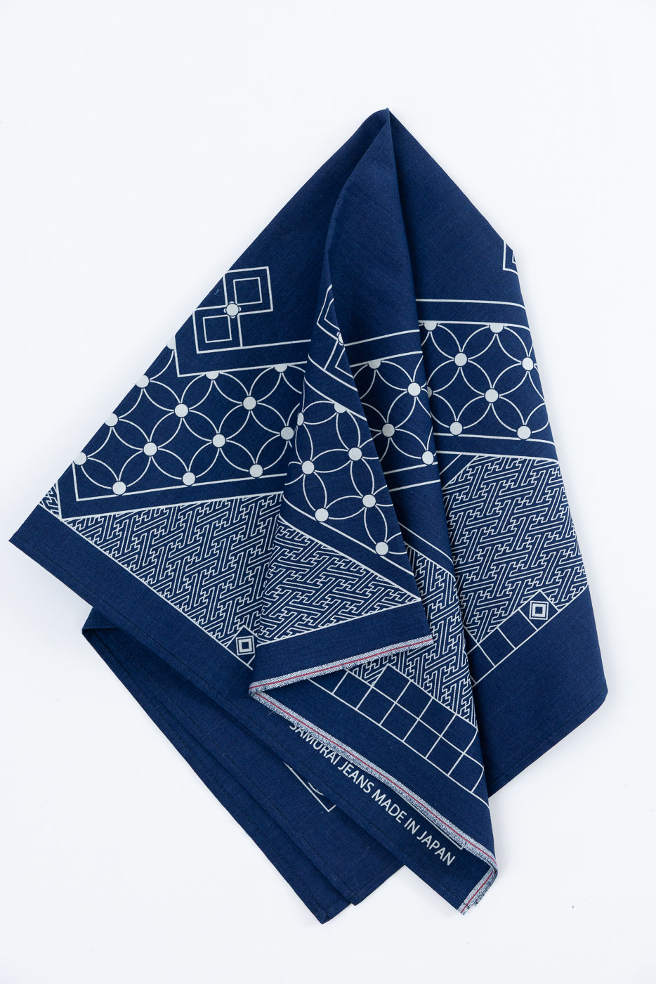 Navy blue bandana with white geometric patterns, front view, folded, showing 'SAMURAI JEANS MADE IN JAPAN' hem tag