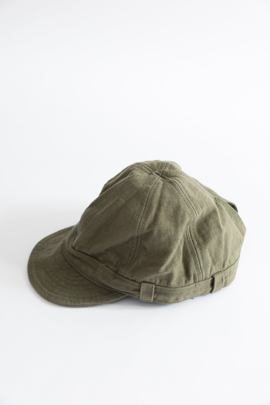 Olive heavy back satin workman's cap flat lay, side angle, showing crown and brim details