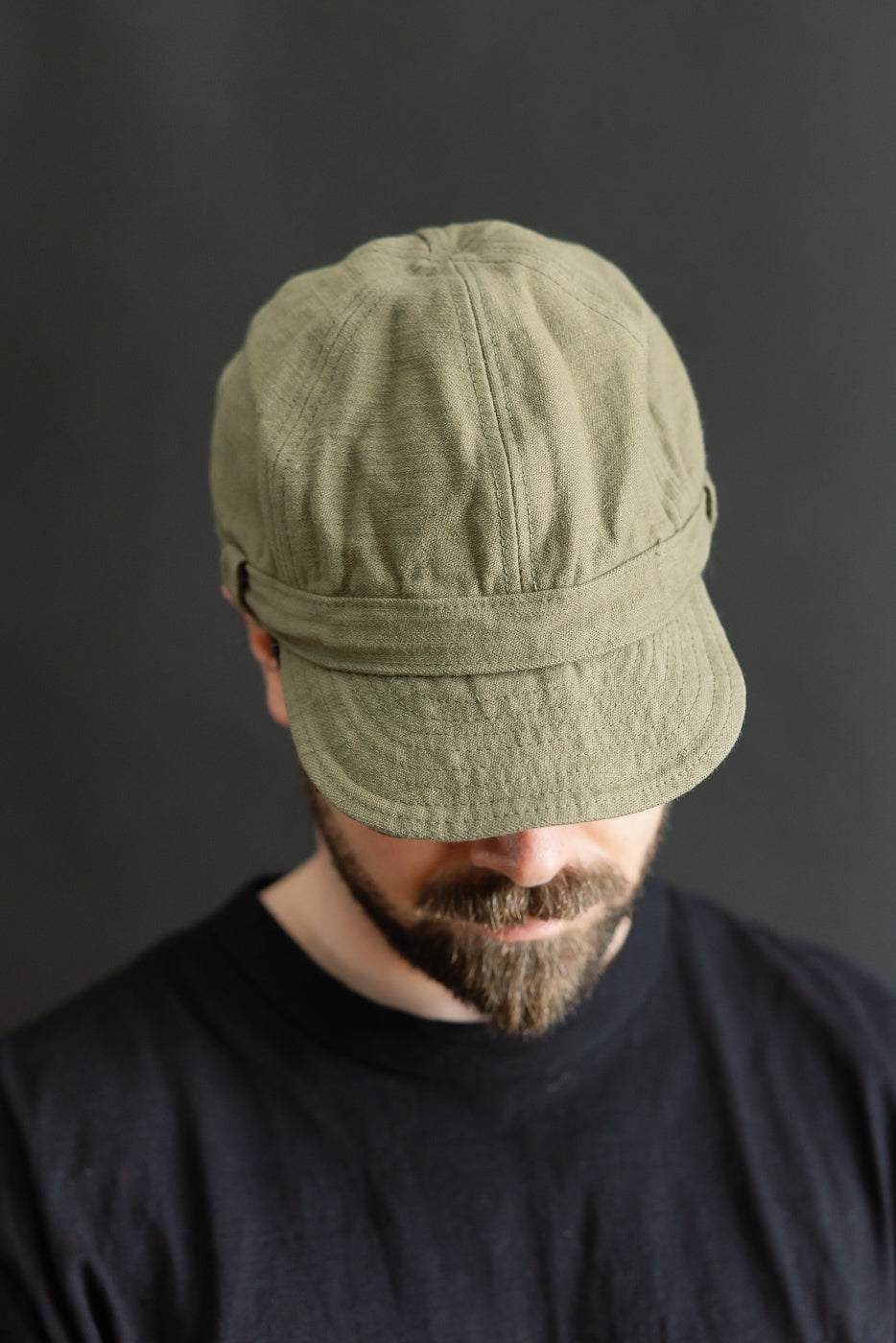 Front view close-up of olive heavy cotton workman’s cap on male model, 5'9