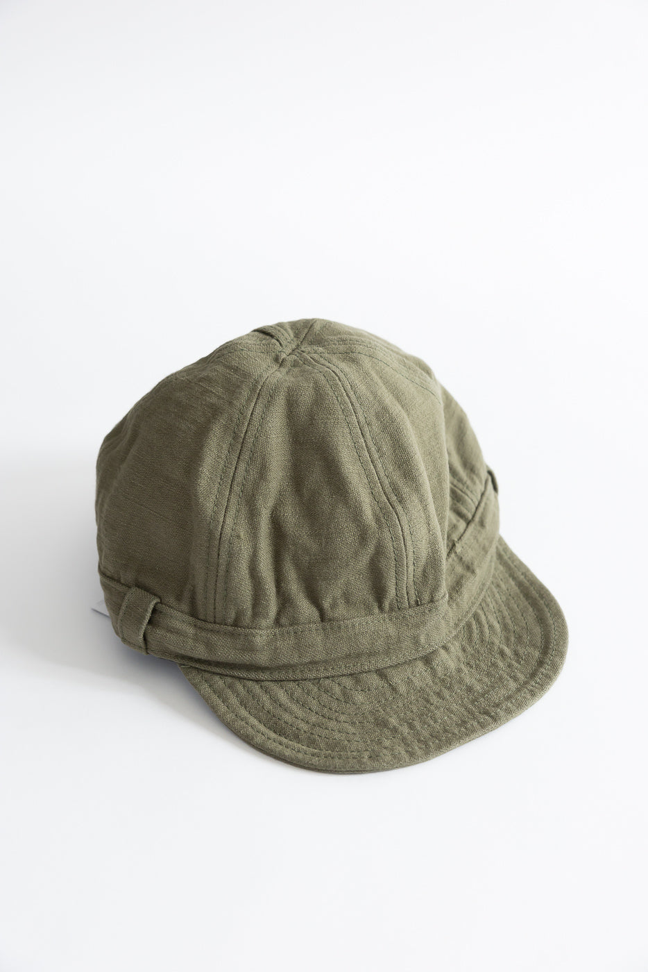 Olive green workman’s cap front side close-up, showing fabric texture and panel stitching.