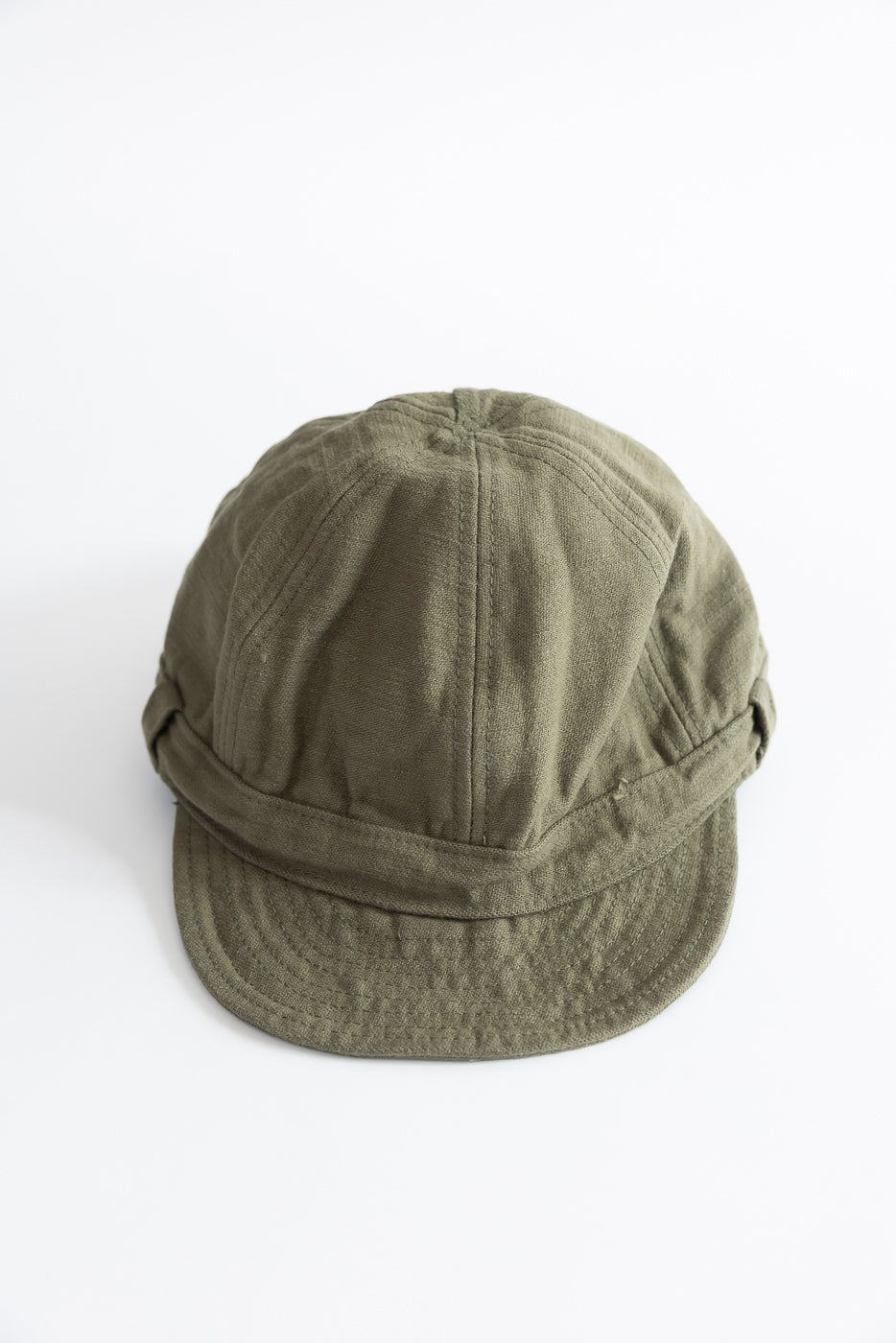 Front view flat lay of olive green heavy back satin work cap, brim and crown details visible.