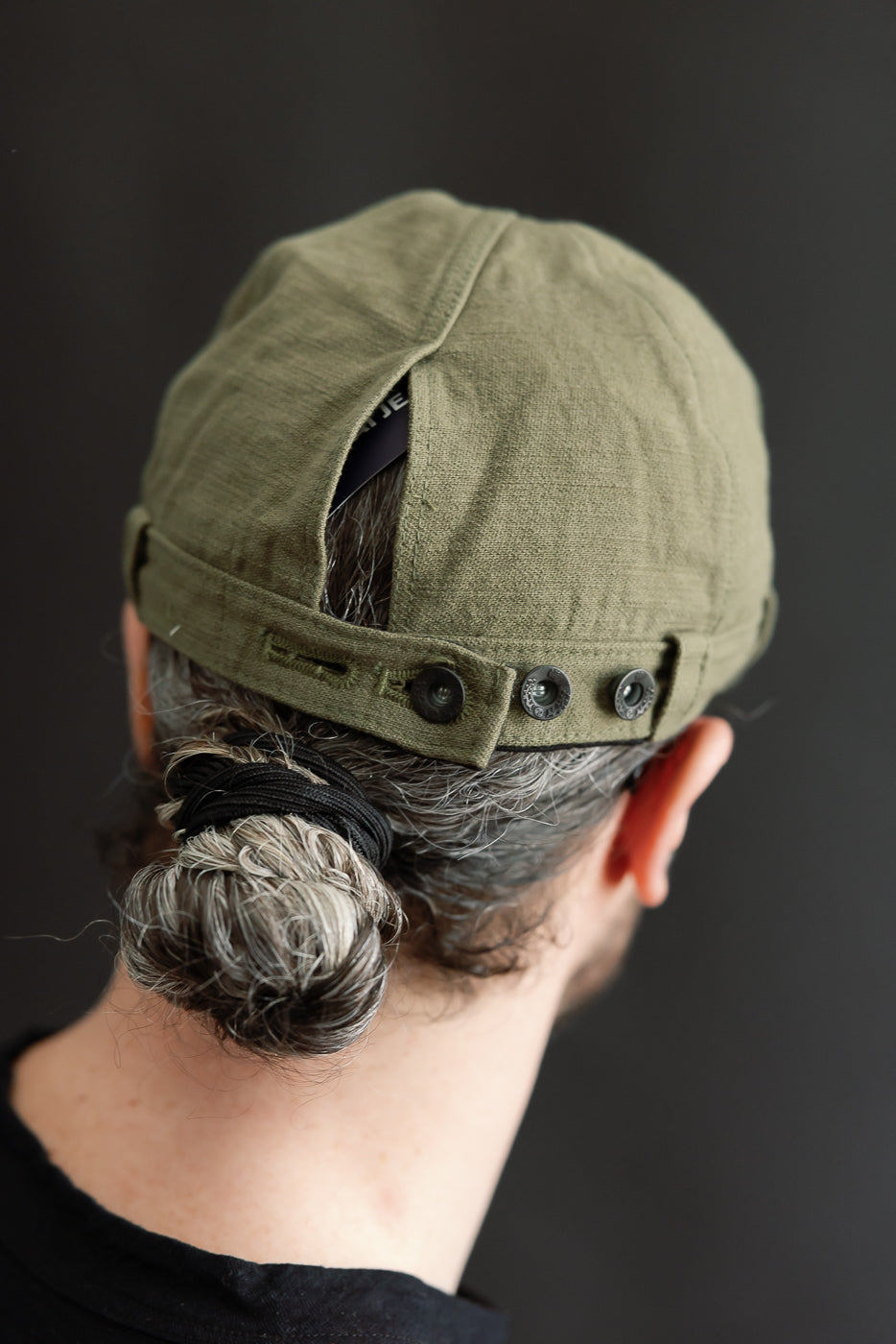 Close-up rear view of olive workman’s cap on male model, 5'9