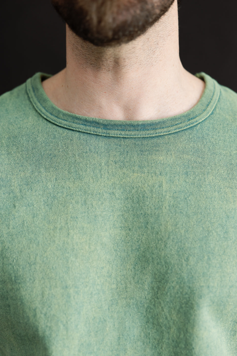 Close-up of front neck and collar detail on green extra heavy t-shirt, male model, athletic build