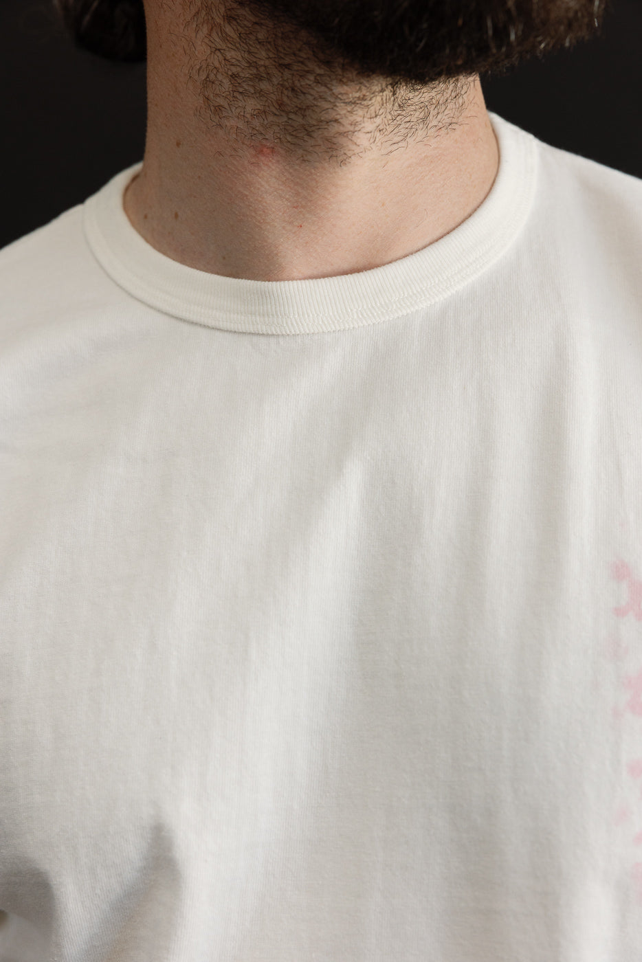 Close-up front view of white crew neck tee on male model, 5'9