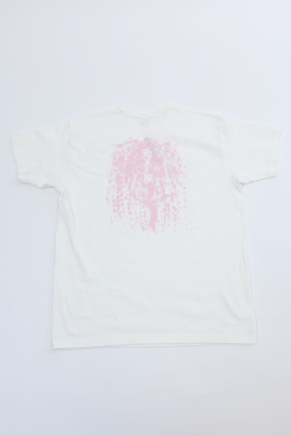 White t-shirt back view, flat lay, pink graphic print with Japanese text, casual apparel