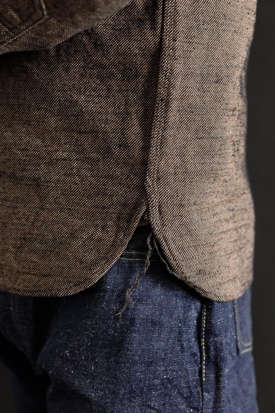Close-up of side hem on Samurai Elemental flannel shirt in black, showing fabric texture and curved edge detail.
