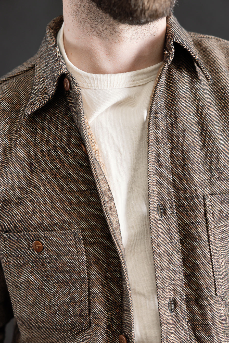 Close-up of front chest and collar detail, Samurai Elemental flannel shirt on male model, showing pockets, button, and textured black flannel fabric.