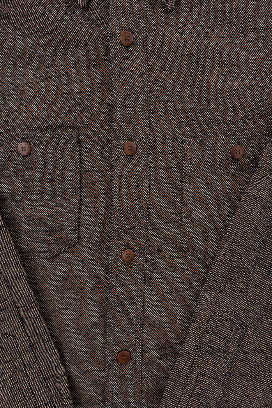 Close-up of front chest area, black flannel shirt with brown buttons, dual chest pockets, textured twill fabric