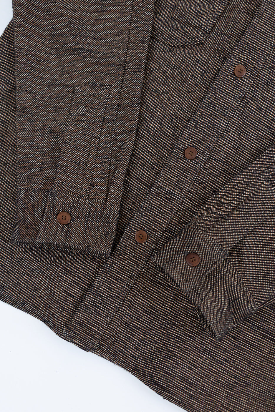 Close-up of Samurai Elemental flannel shirt front, brown-black textured fabric, button details, sleeve cuffs, flat lay.