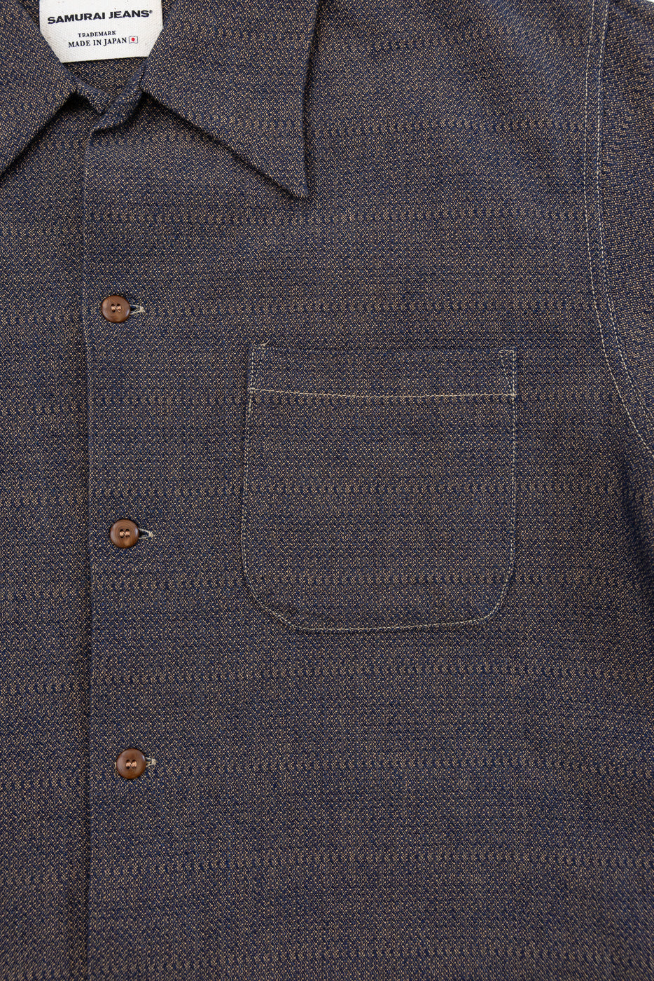 Close-up front view of dark indigo selvedge shirt with chest pocket, brown buttons, and Samurai Jeans tag