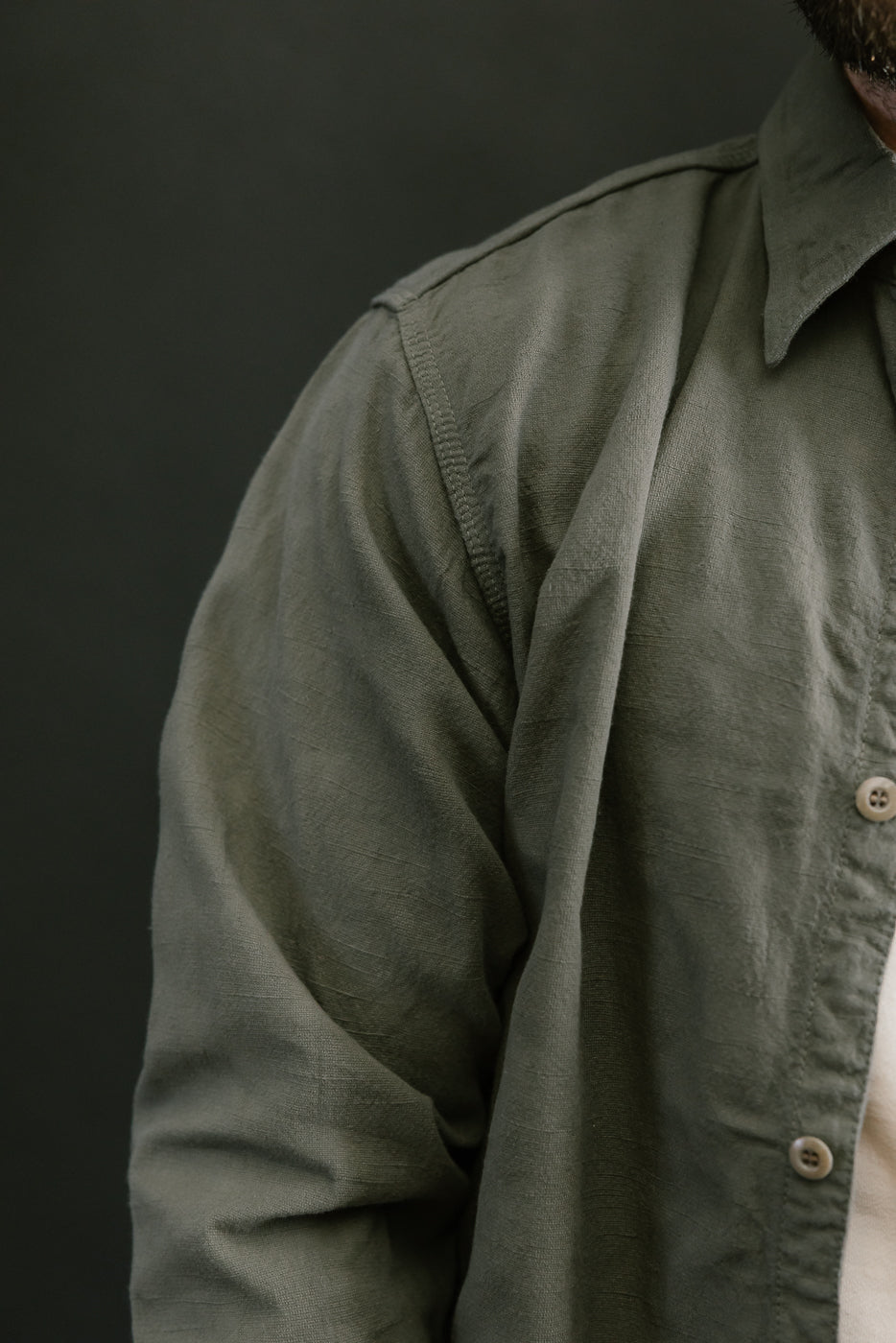 Close-up of the Tropical Weather Dobby Shirt in olive green, showcasing its textured Panama-weave fabric and part of the collar and button details.