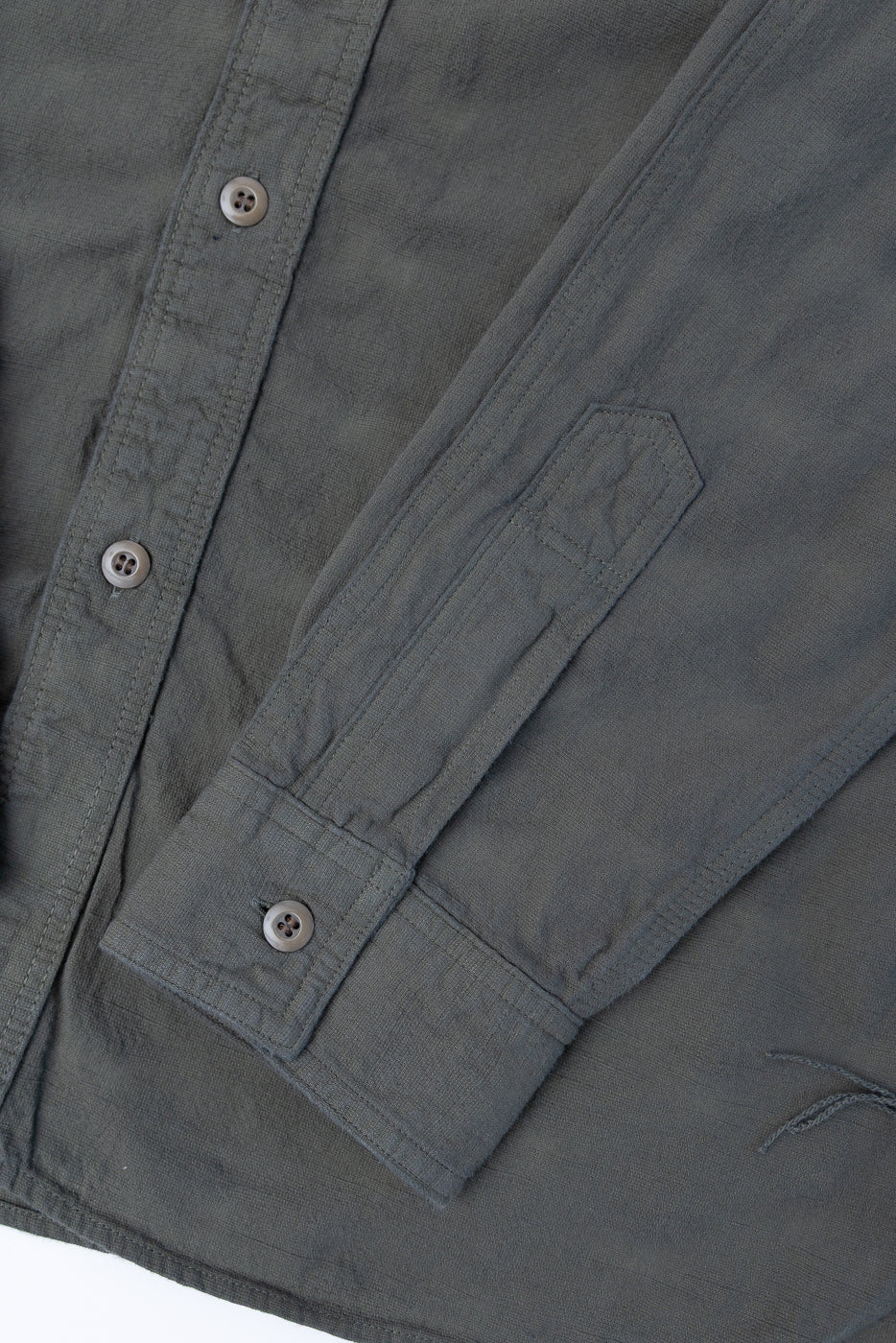 Close-up of the SSS25-ATW Tropical Weather Dobby Shirt in olive green, showcasing its button-up front, textured dobby fabric, and durable stitching.