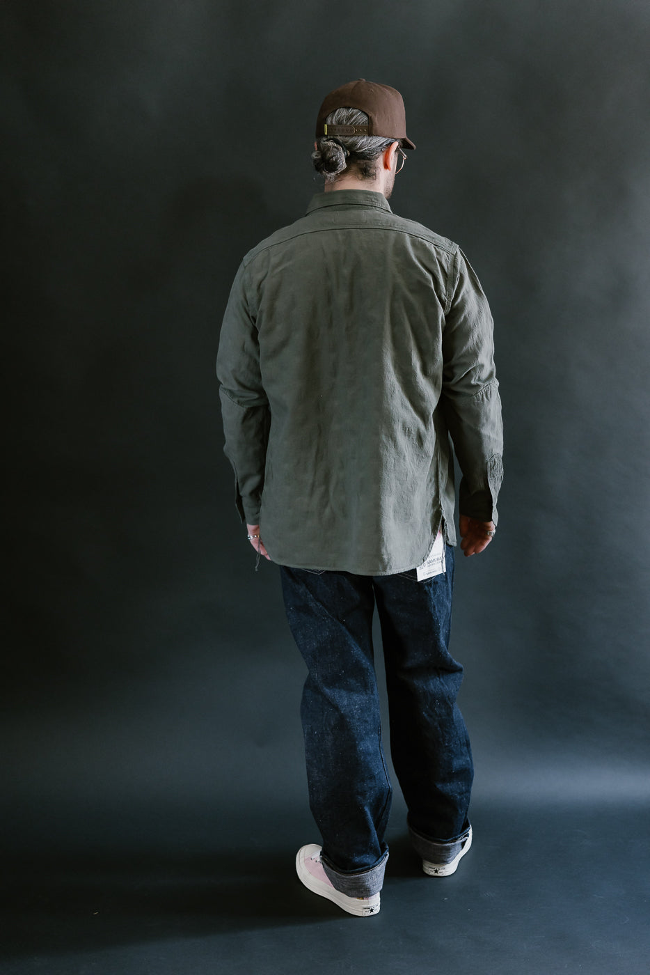 Person wearing the SSS25-ATW Tropical Weather Dobby Shirt in olive green, styled with selvedge denim jeans and sneakers, showcasing a casual workwear-inspired look.