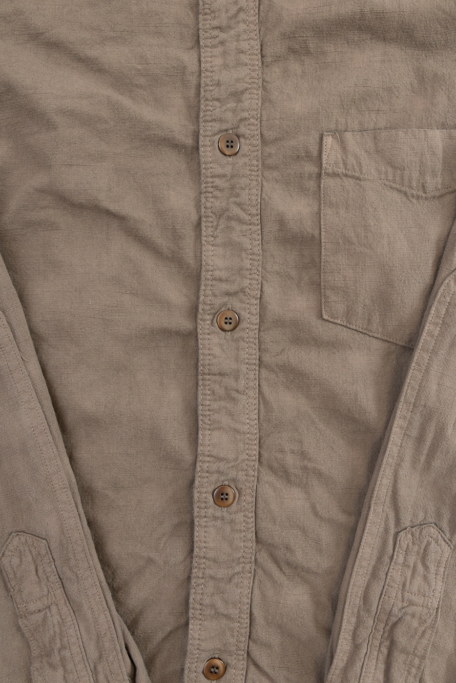Close-up front view of men's button-up shirt showing chest pocket, fabric texture, and button details