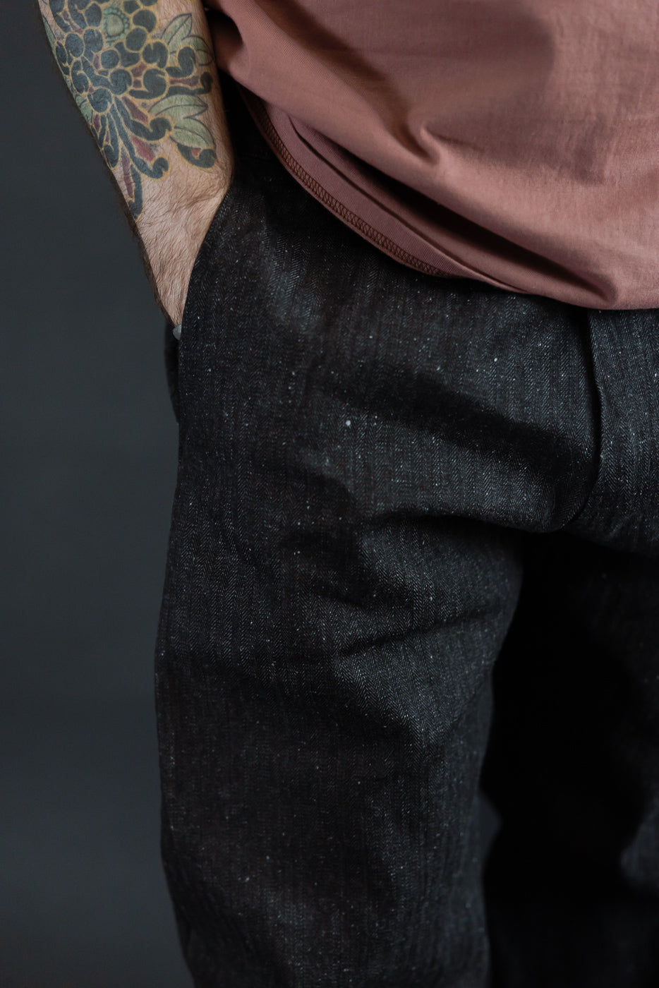 Close-up of male model's side, showcasing dark selvedge denim texture and fit, 5'9