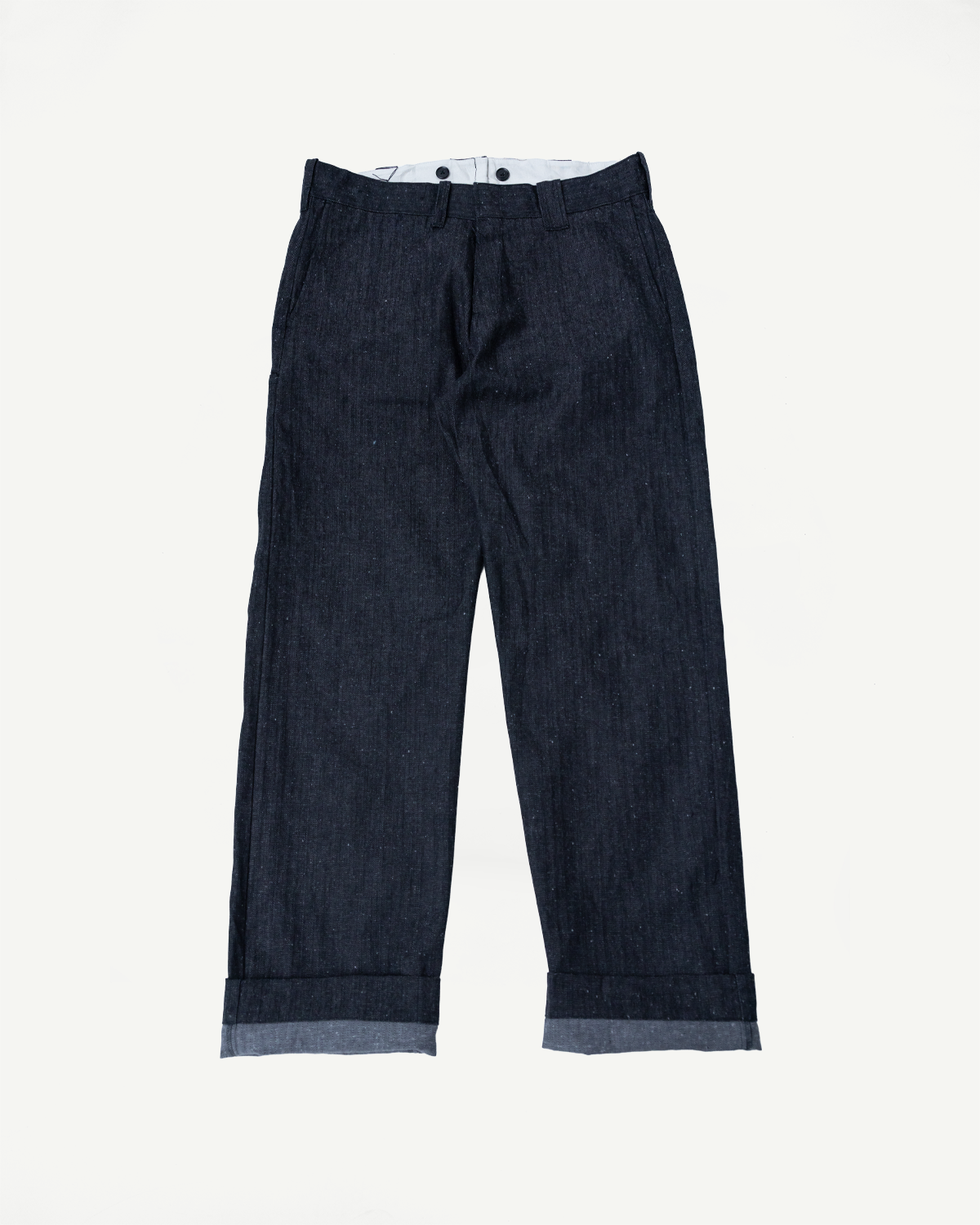 Front view of dark selvedge denim trousers with cuffed hems, flat lay