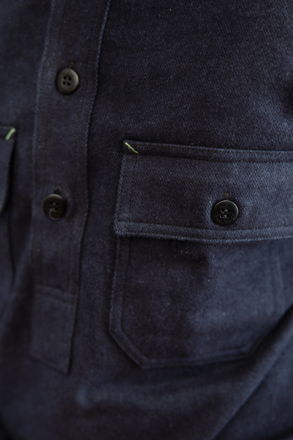 Close-up front view of dark shirt showing button details, chest pocket, and fabric texture