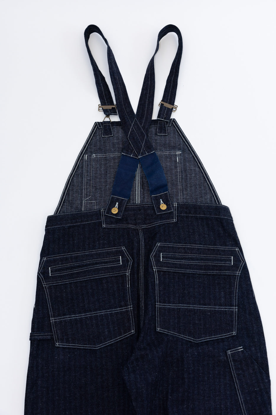Front view of dark denim overalls with white stitching, adjustable straps, and front pockets