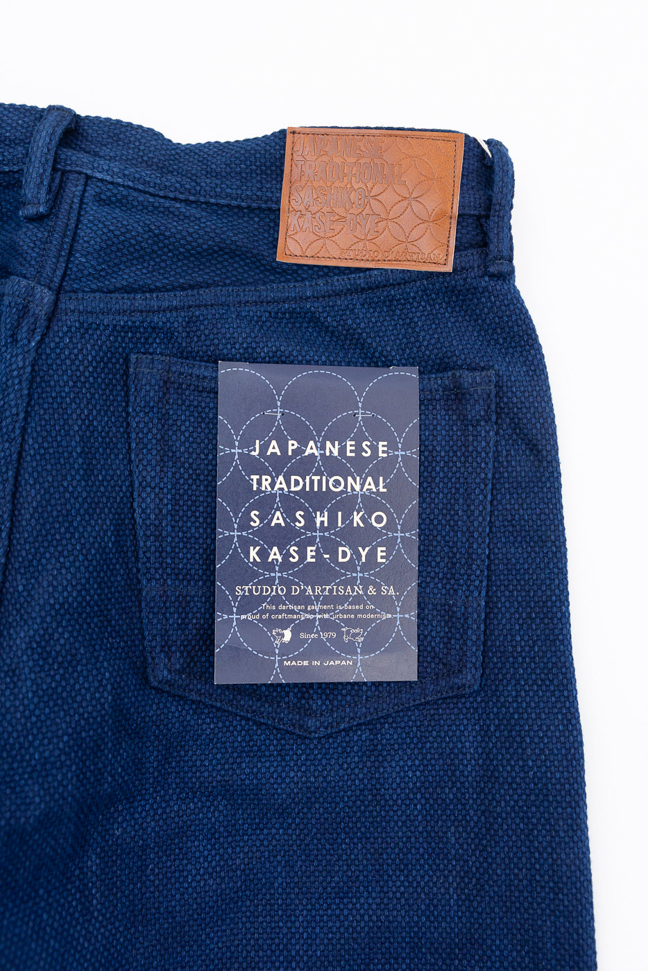 Close-up of back of blue selvedge pants with leather tag and Japanese Sashiko Kase-Dye label