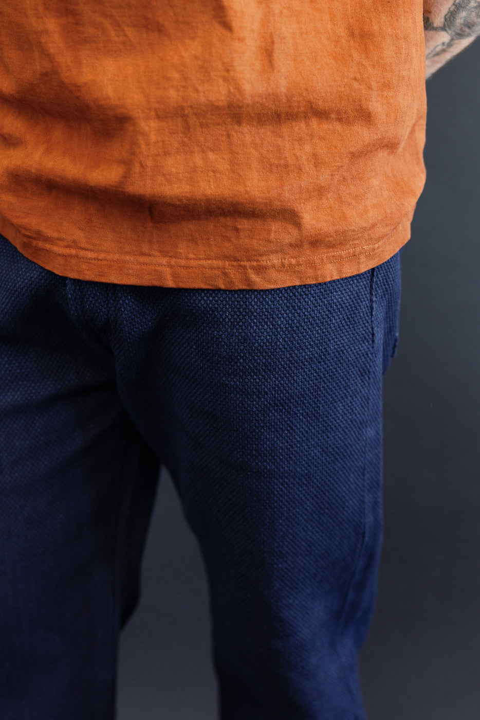 Close-up front view of navy textured pants on male model, 5'9