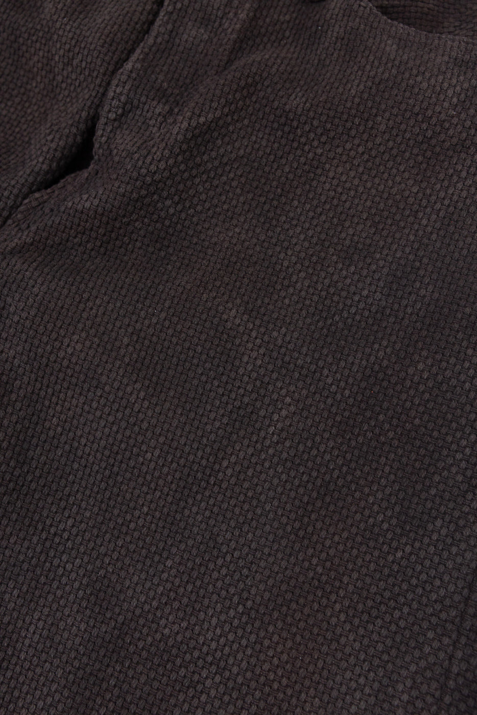 Close-up of dark brown textured fabric, front view, showing detailed weave pattern and soft material texture.